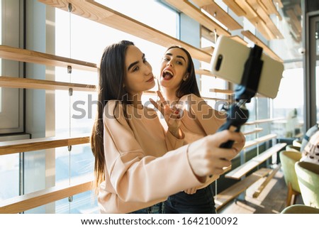 twins girl doing selfie on cellphone