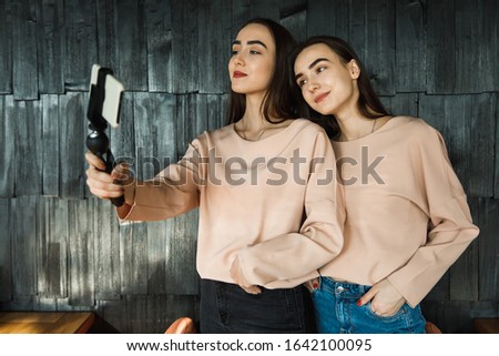 twins girl doing selfie on cellphone