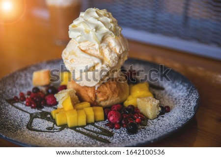 Vanilla ice cream topped with fruit topping Royalty-Free Stock Photo #1642100536