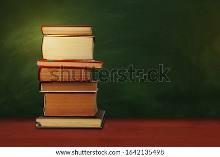 Back to school, pile of books with empty green school board background, education concept