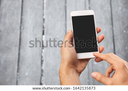 Human hand hold smart phone with blank screen