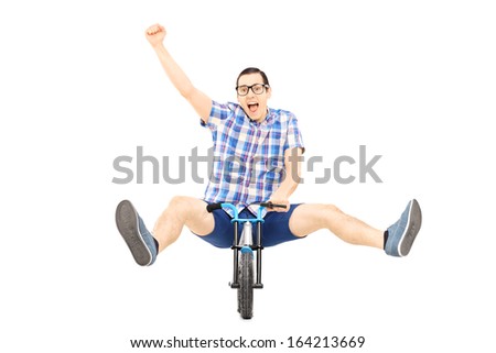 Excited young male riding a small bicycle and gesturing happiness isolated on white background