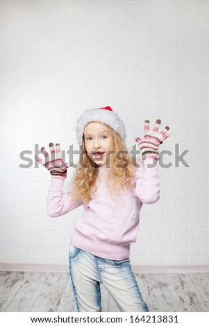 Child in christmas hat on white background. Happy little girl