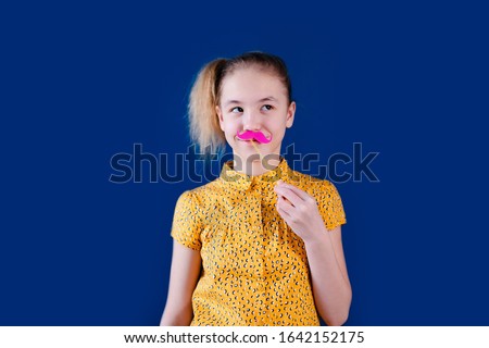 Birthday party and young girl in hats and props on blue background.