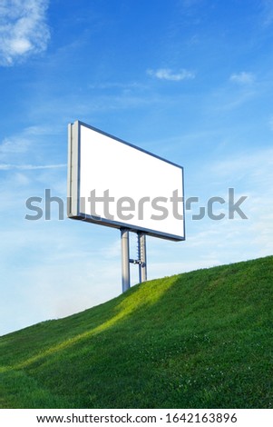 A blank advertising billboard in a grass field - image with copy space