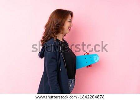 Young Russian woman over isolated pink background with skate in lateral position