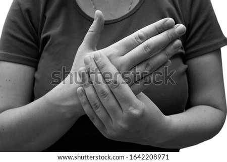 The woman has a sore arm. Pain in the palm, isolated. Black and white photo.