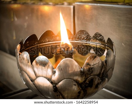 Picture of lotus shape steel base with flamed candle, lit on doi suthep, famous sightseeing place of Chaingmai, Thailand