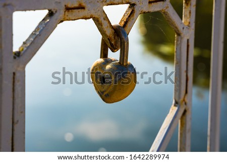 Metal lock in the form of heart on the iron fence, symbol of love.
