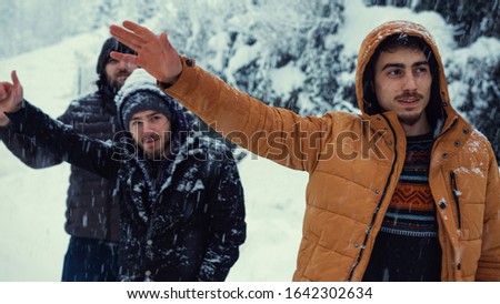 While it is snowing on a winter day, the cold men makes a hand sign to stop the bus.Transportation concept in winter.