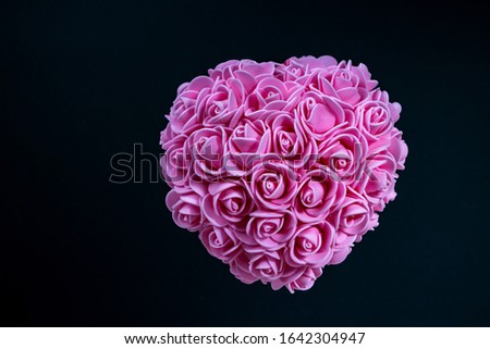 Valentine's Day, romantic still life, pink heart of pink flowers, blurred dark blue background, shallow depth of field. Beautiful holiday picture.