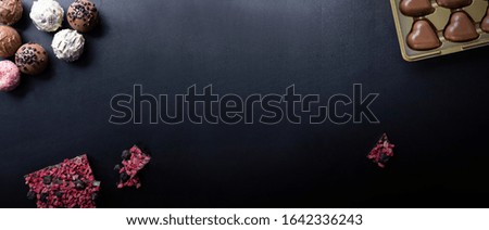 Gourmet chocolates on a dark background, wide banner with copy space. Valentine's Day, love, romantic moment.