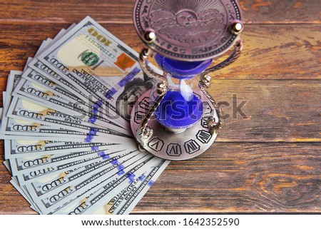 Dollar banknotes and hourglass. The concept of fast credit processing.