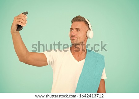 Selfie in gym concept. Sportsman smartphone and headphones. Healthy lifestyle. Gym aesthetics. Mature but still in good shape. Exercising in gym for better health. Man athlete taking selfie photo.