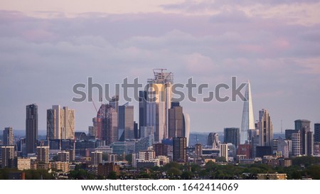 View of a group of buildings forming a skyline at sunset with clouds in the background