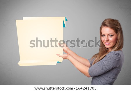 Beautiful young woman holding white origami paper copy space