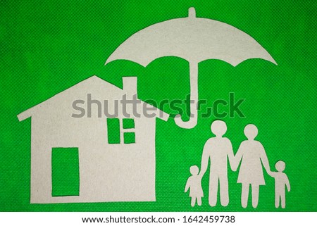 Paper cut family silhouette in a cardboard hand on cardboard background.