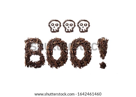 Boo! quote and skulls made with dried tea leaves placed on white background from the top view can use for your messages