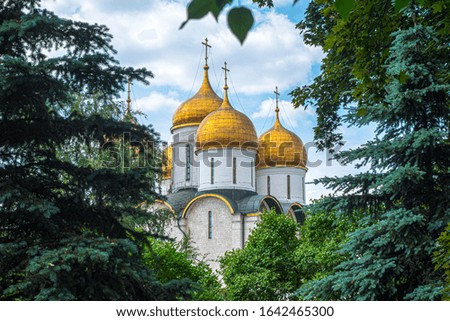 Dormition Cathedral inside Kremlin surrounded by trees in summer, Moscow, Russia. Royalty free stock photo.