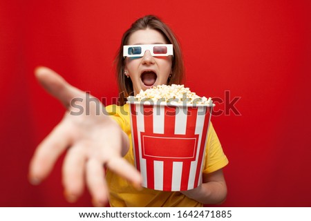 shocked girl in 3D glasses watching a movie and screaming on a red background, copy space
