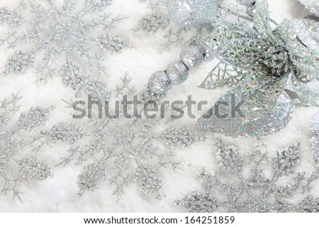 Silver christmas baubles on white snow background
