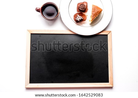 A picture of blackboard with copyspace, cup of Turkish coffee, moist cheesecake and special design chocolate 