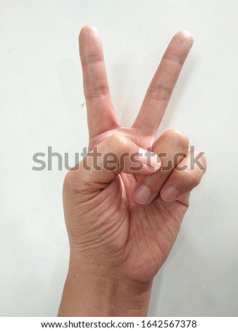 
The picture shows the gesture of a hand holding two fingers