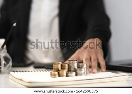 Silver and gold coins stacked on the work desk,Money for business, growth and investment