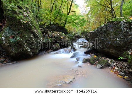 Waterfall in a forest river in autumn