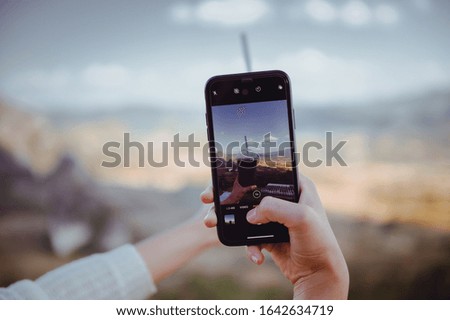 Hand of asian woman taking a picture of coffee cup with a mobile phone