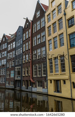 Beautiful colorful houses on a canal in Amsterdam. Vertical.