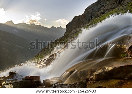 sunny waterfall in mountains