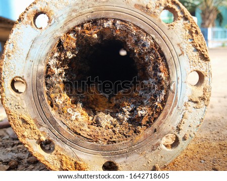 Closeup of waste in old water pipes Clogged debris and corroded rust in old plumbing pipes on the cement courtyard background. Maintenance of water supply system. Selective focus Royalty-Free Stock Photo #1642718605