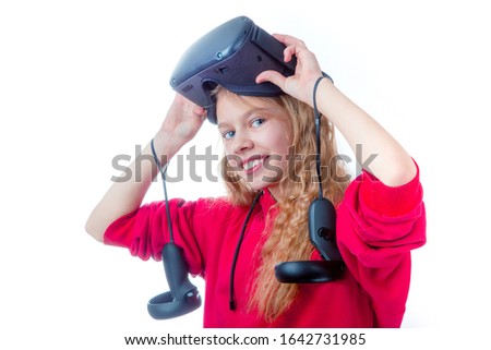 Amazed teen girl wearing virtual reality goggles or playing video games looking in VR glasses. Emotional portrait of child experiencing 3D gadget. On white backgroun.