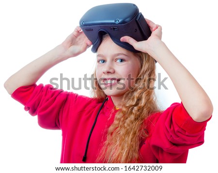 Amazed teen girl wearing virtual reality goggles or playing video games looking in VR glasses. Emotional portrait of child experiencing 3D gadget. On white backgroun.