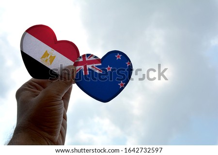 Hand holds a heart Shape Egypt and New Zealand New Zealand flag, love between two countries