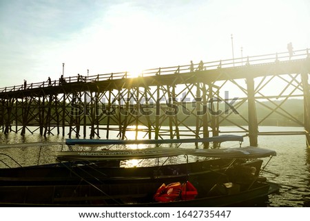 Picture from the pier area near the Uttmanuson Bridge, which is the longest wooden bridge in Thailand, located at Sangkharakri District, Kanchanaburi Province, Thailand.