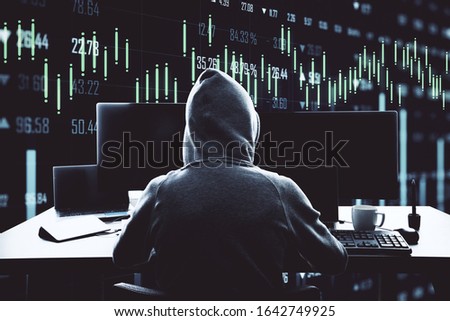 Unrecognizable hacker using computer with stock chart. Hacking and malware concept