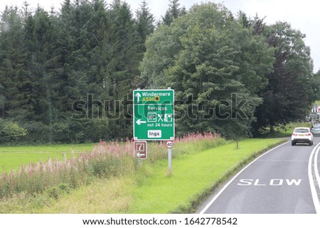 Traffic Signs on the road to winder mere with a back drop of trees