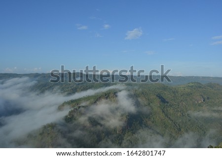 
the peak of the building in the morning with soft fog and blue sky background