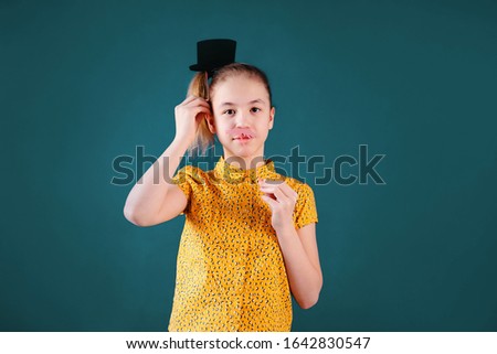 Birthday party and young girl in hats and props on blue background.