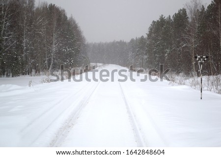 Snow-covered railway in the middle of a winter forest. Blurred photo bokeh 