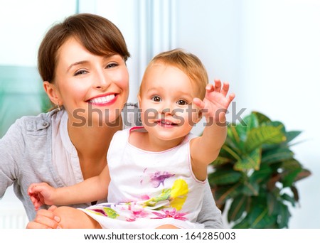 Mother and Baby kissing and hugging at Home. Mum and her Child - Little Daughter. Happy Smiling Family Portrait 