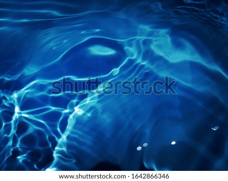 The​ abstract​ of​ surface​ blue​ water​ in​ the swimming​ pool​ for​ blue​ background​