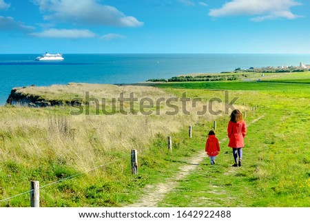 mom and her pretty little daughter on a walk on the coast in the north of France