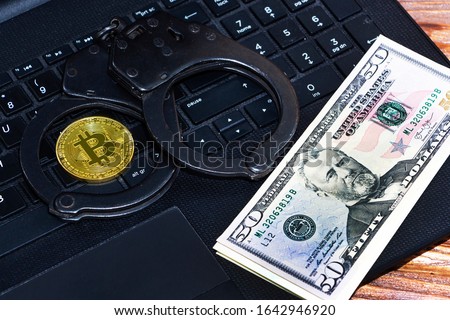 Police handcuffs and bitcoins. The concept of problems with the law in the illegal mining of cryptocurrencies and transactions with bitcoins