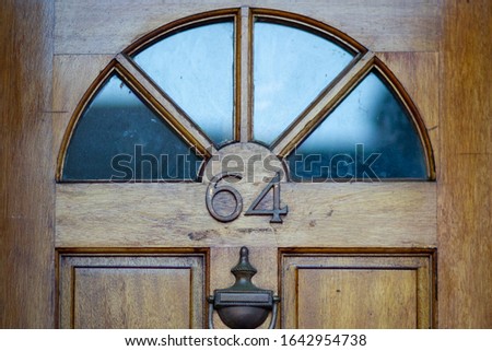 House number 64 on an old wooden front door