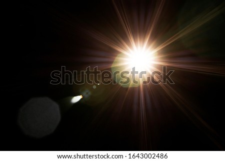Flash of a distant abstract star. Lens Flare effect close up. Different colors (green, red, white, yellow) light on black background. Abstract sun burst. Easy to add overlay filter over photos, images