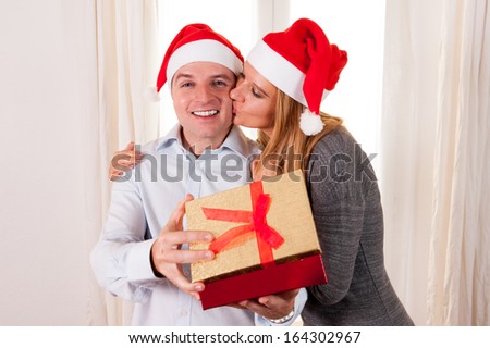 Happy Young Man Opening Christmas Present with beautiful woman