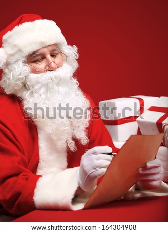 Portrait of Santa Claus looking at envelope in his hands 